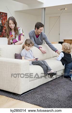 Family in a living room View Large Photo Image Picture - Family in a living room. Fotosearch