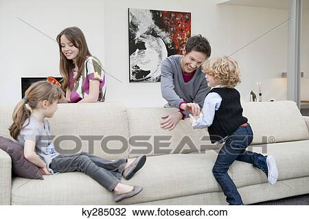 Family in a living room View Large Photo Image Stock Image - Family in a living room. Fotosearch