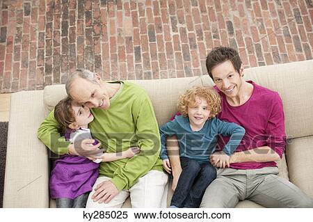 Family sitting on a couch View Large Photo Image Stock Photography - Family sitting on a couch. Fotosearch