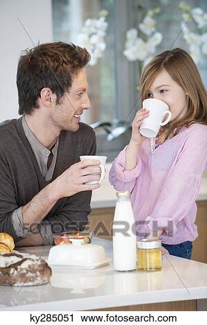 Man drinking coffee with his daughter View Large Photo Image Stock Image - Man drinking coffee with his daughter. Fotosearch