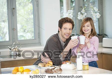 Stock Photo - Man drinking coffee with his daughter. Fotosearch