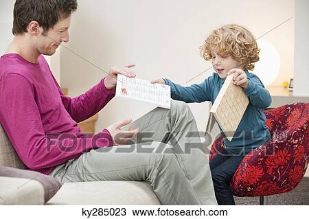 Man giving a book to his son View Large Photo Image Stock Image - Man giving a book to his son. Fotosearch