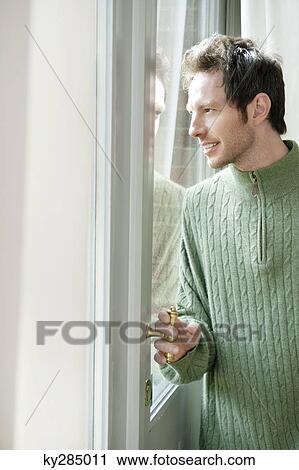 Man looking out through a door glass View Large Photo Image Stock Image - Man looking out through a door glass. Fotosearch