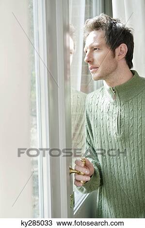 Man looking out through a door glass View Large Photo Image Stock Image - Man looking out through a door glass. Fotosearch