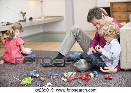 Man playing with his son in a living room View Large Photo Image Stock Photo - Man playing with his son in a living room. Fotosearch