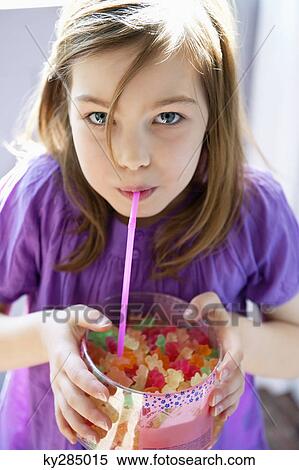 Stock Photography - Portrait of a girl holding a box full of gum drops. Fotosearch