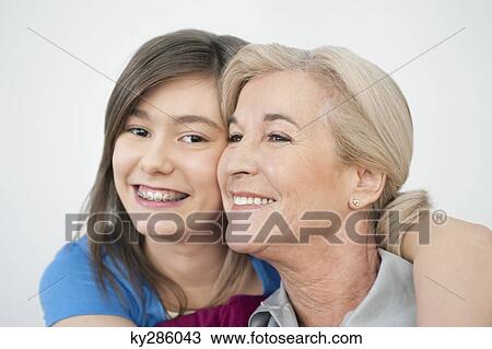 Close-up of a woman smiling with her granddaughter View Large Photo Image Stock Image - Close-up of a woman smiling with her granddaughter. Fotosearch