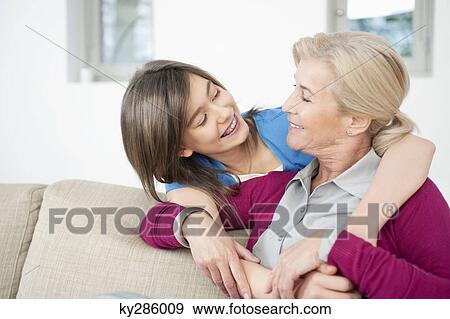 Close-up of a woman smiling with her granddaughter View Large Photo Image Stock Photo - Close-up of a woman smiling with her granddaughter. Fotosearch