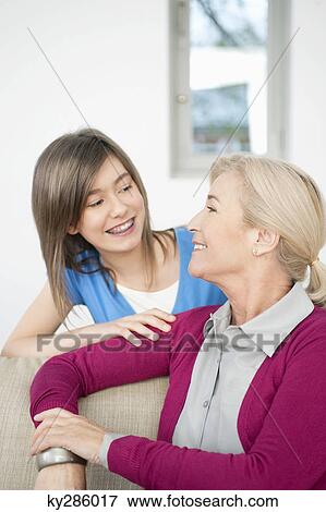 Close-up of a woman smiling with her granddaughter View Large Photo Image Stock Photo - Close-up of a woman smiling with her granddaughter. Fotosearch