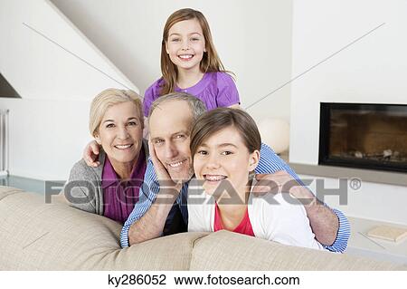 Stock Image - Couple smiling with their granddaughters. Fotosearch