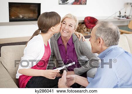 Girl kissing her grandmother with her grandfather sitting beside them View Large Photo Image Stock Image - Girl kissing her grandmother with her grandfather sitting beside them. Fotosearch