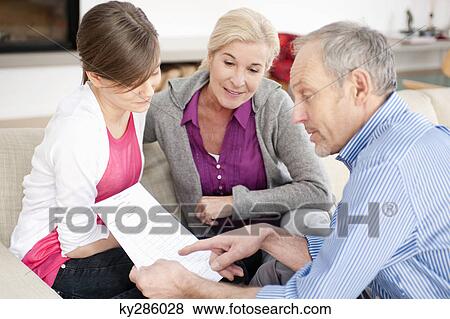 Man explaining a document to his granddaughter View Large Photo Image Stock Photo - Man explaining a document to his granddaughter. Fotosearch
