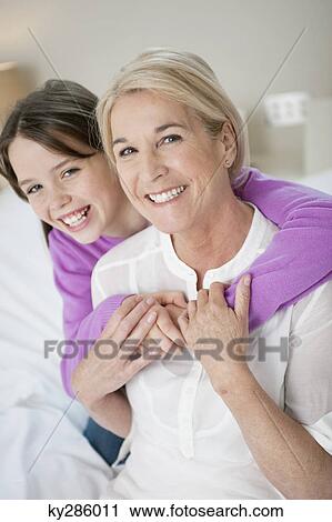 Portrait of a girl hugging her grandmother View Large Photo Image Stock Image - Portrait of a girl hugging her grandmother. Fotosearch