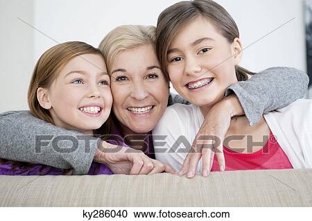 Portrait of a woman smiling with her granddaughters View Large Photo Image Stock Image - Portrait of a woman smiling with her granddaughters. Fotosearch