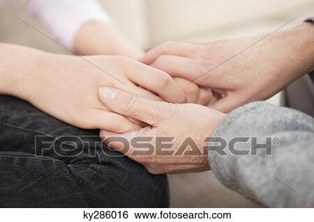 Stock Photograph - Woman holding hands of her granddaughter. Fotosearch