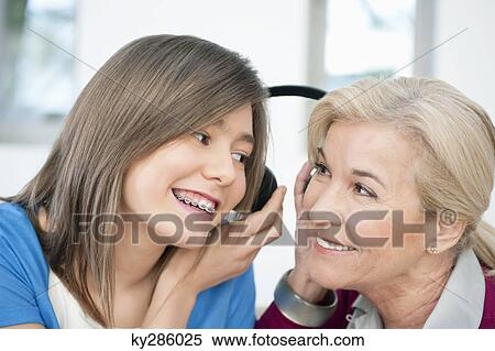 Woman with her granddaughter listening to headphones View Large Photo Image Stock Photography - Woman with her granddaughter listening to headphones. Fotosearch