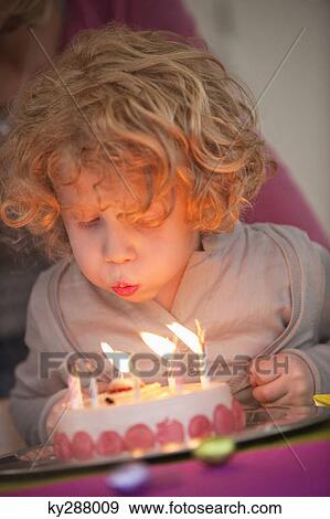 Boy blowing out candles on his birthday cake View Large Photo Image Stock Photo - Boy blowing out candles on his birthday cake. Fotosearch