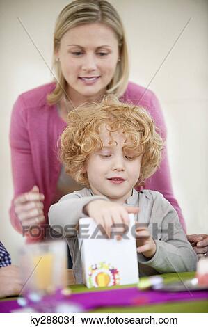 Picture - Boy opening his birthday present. Fotosearch