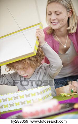 Stock Photo - Boy opening his birthday present. Fotosearch