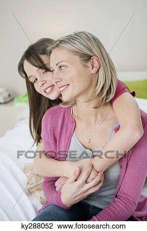 Girl hugging her mother from behind View Large Photo Image Stock Image - Girl hugging her mother from behind. Fotosearch
