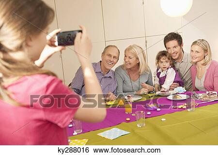 Girl taking a picture of her family with a camera phone View Large Photo Image Stock Photograph - Girl taking a picture of her family with a camera phone. Fotosearch