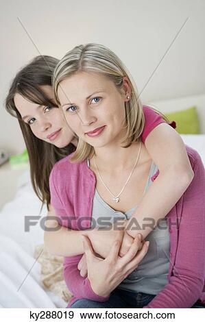 Portrait of a girl hugging her mother from behind View Large Photo Image Stock Photo - Portrait of a girl hugging her mother from behind. Fotosearch