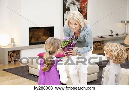 Woman giving a potted plant to her granddaughter View Large Photo Image Stock Image - Woman giving a potted plant to her granddaughter. Fotosearch