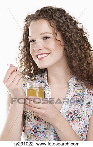 Stock Image - Close-up of a woman eating honey. Fotosearch