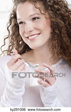 Close-up of a woman eating yogurt View Large Photo Image Stock Photograph - Close-up of a woman eating yogurt. Fotosearch