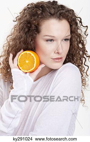 Close-up of a woman holding a half of an orange View Large Photo Image Picture - Close-up of a woman holding a half of an orange. Fotosearch