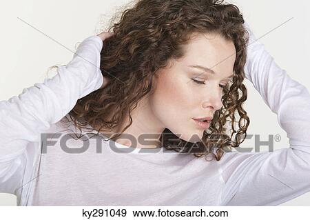 Close-up of a woman with hand in hair View Large Photo Image Stock Photo - Close-up of a woman with hand in hair. Fotosearch