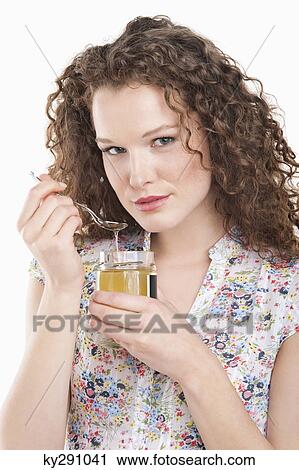 Portrait of a woman eating honey View Large Photo Image Stock Image - Portrait of a woman eating honey. Fotosearch