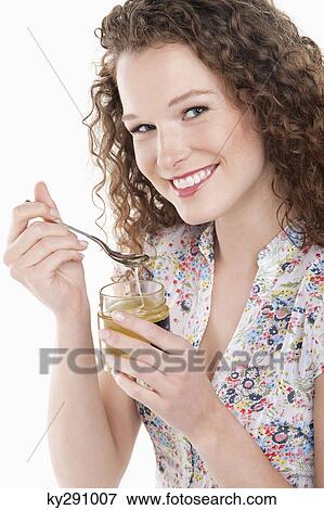 Portrait of a woman eating honey View Large Photo Image Stock Photo - Portrait of a woman eating honey. Fotosearch