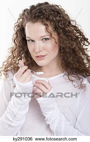 Portrait of a woman eating yogurt View Large Photo Image Stock Photograph - Portrait of a woman eating yogurt. Fotosearch