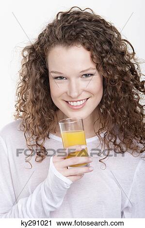 Portrait of a woman holding a glass of orange juice View Large Photo Image Stock Image - Portrait of a woman holding a glass of orange juice. Fotosearch