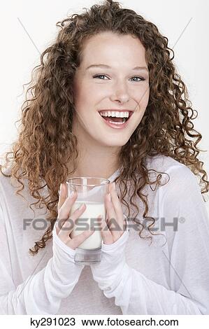 Portrait of a woman holding a glass of milk and laughing View Large Photo Image Stock Image - Portrait of a woman holding a glass of milk and laughing. Fotosearch