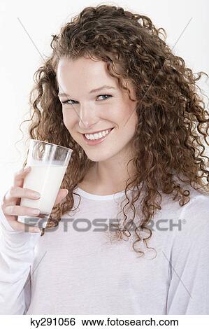 Stock Photograph - Portrait of a woman holding a glass of milk and smiling. Fotosearch