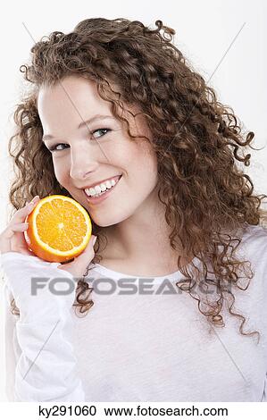 Portrait of a woman holding a half of an orange View Large Photo Image Stock Image - Portrait of a woman holding a half of an orange. Fotosearch