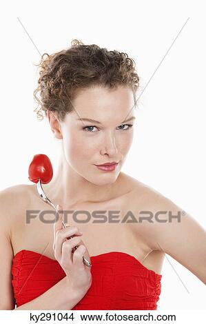 Portrait of a woman holding a tomato on a fork View Large Photo Image Picture - Portrait of a woman holding a tomato on a fork. Fotosearch
