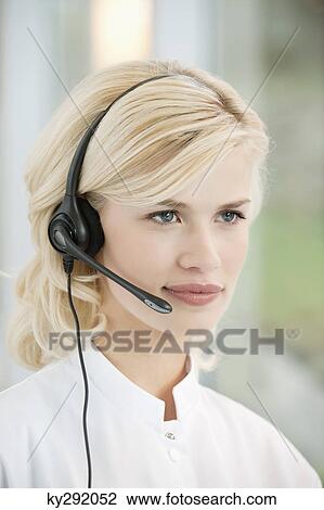 Stock Image - Close-up of a female customer service representative wearing a headset. Fotosearch