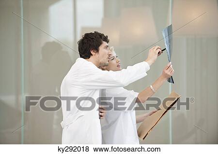 Doctors examining an x-ray report View Large Photo Image Stock Photo - Doctors examining an x-ray report. Fotosearch