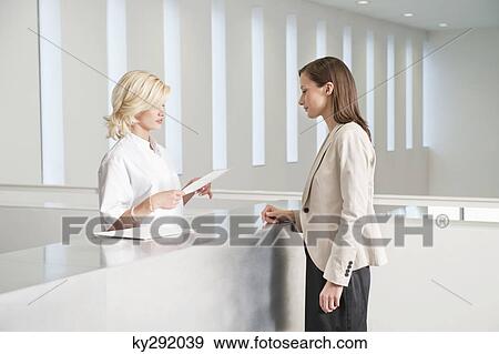 Stock Photo - Female nurse examining a medical report. Fotosearch