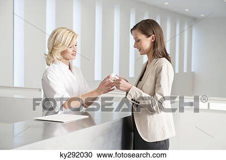 Female nurse giving medicine to a woman View Large Photo Image Stock Image - Female nurse giving medicine to a woman. Fotosearch