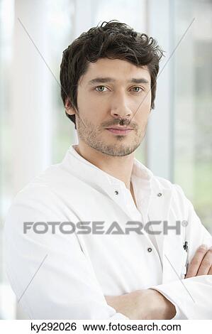 Stock Photograph - Male doctor standing with his arms crossed. Fotosearch