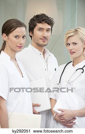 Stock Image - Portrait of three doctors smiling. Fotosearch