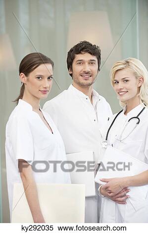 Stock Photography - Portrait of three doctors smiling. Fotosearch