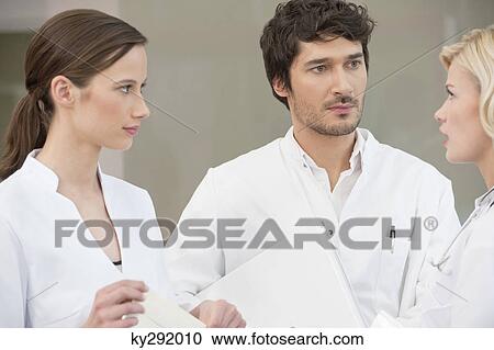 Three doctors discussing each other View Large Photo Image Stock Image - Three doctors discussing each other. Fotosearch