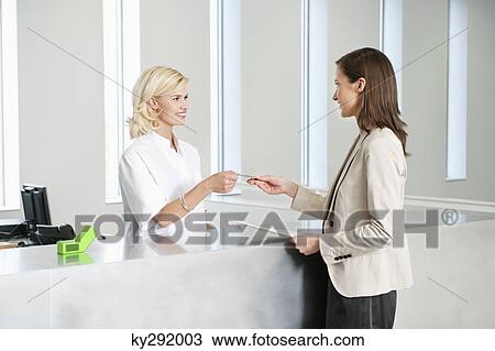 Woman making payment with credit card in a hospital View Large Photo Image Stock Image - Woman making payment with credit card in a hospital. Fotosearch
