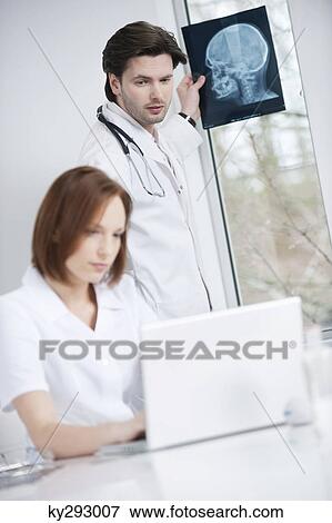Doctors working in an office View Large Photo Image Stock Photo - Doctors working in an office. Fotosearch