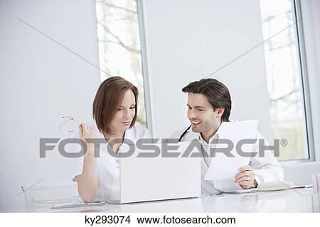 Doctors working on a laptop View Large Photo Image Picture - Doctors working on a laptop. Fotosearch